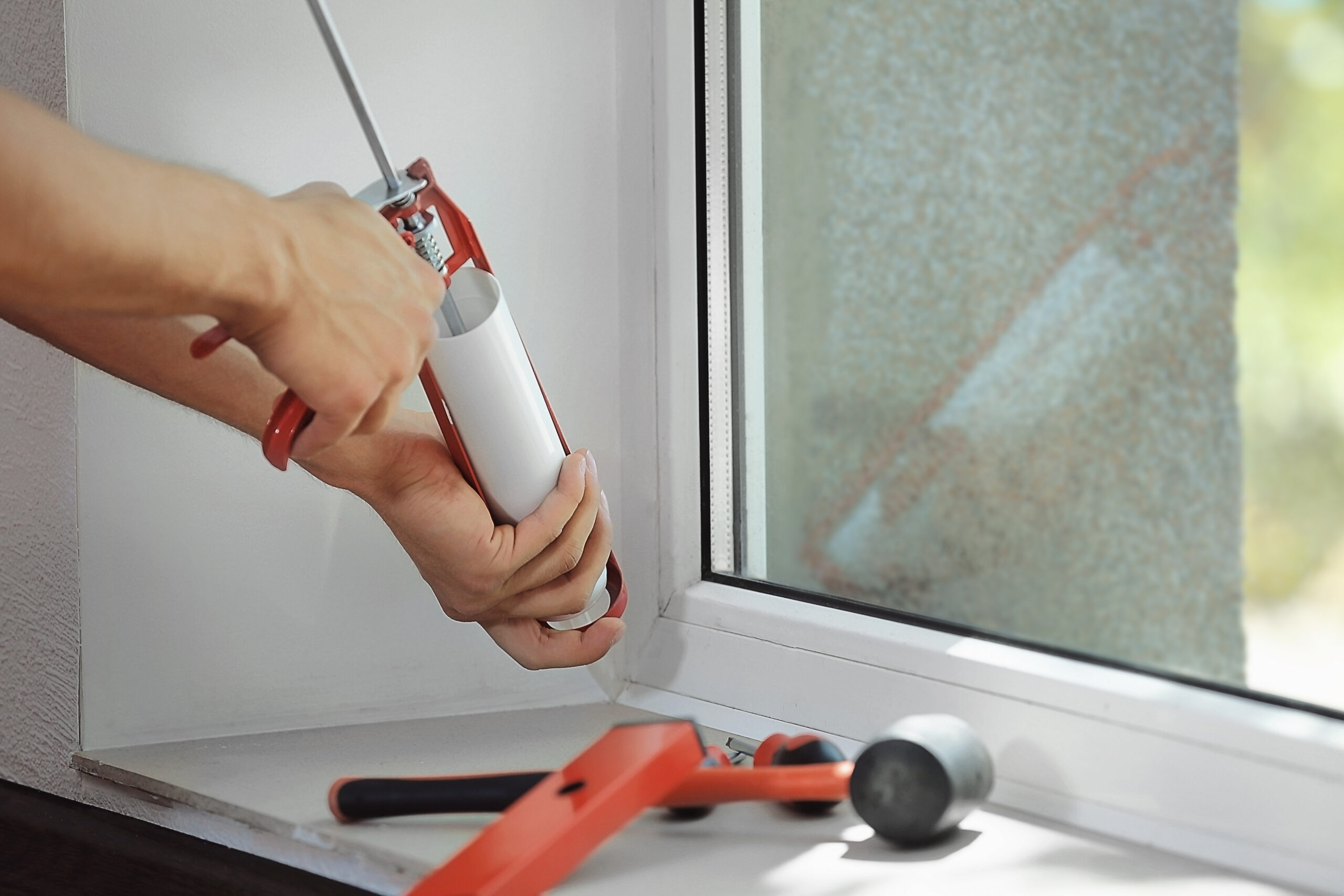 Construction worker installing window in house