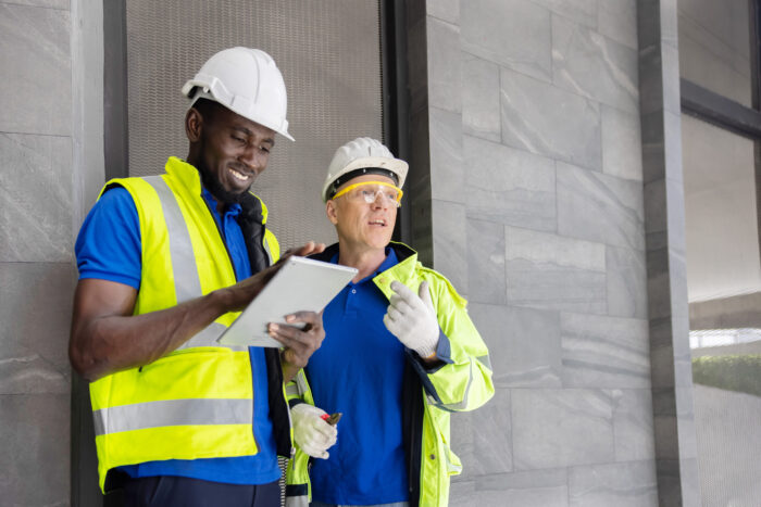 Two Industry Engineers Use Digital Tablet to Discuss about Their Work